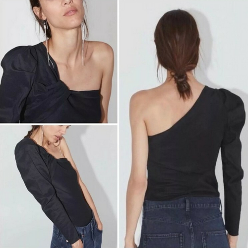 Black one-shoulder top worn by a model on a white background