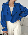 Person wearing a blue jacket with a gray couch in the background