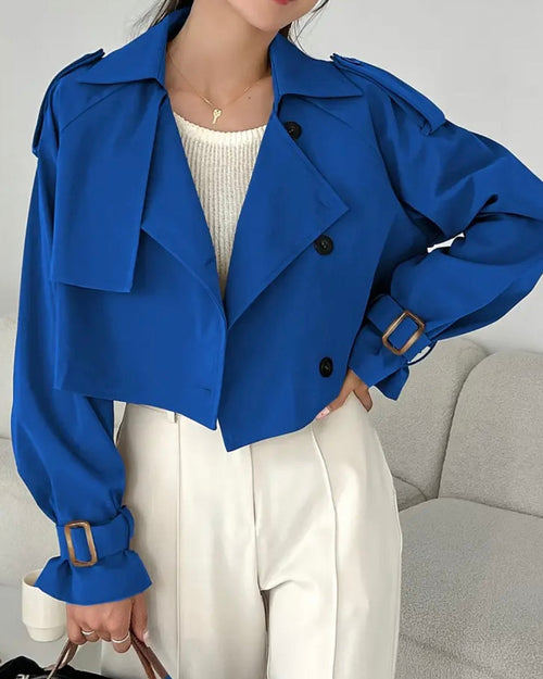 Person wearing a blue jacket with a gray couch in the background