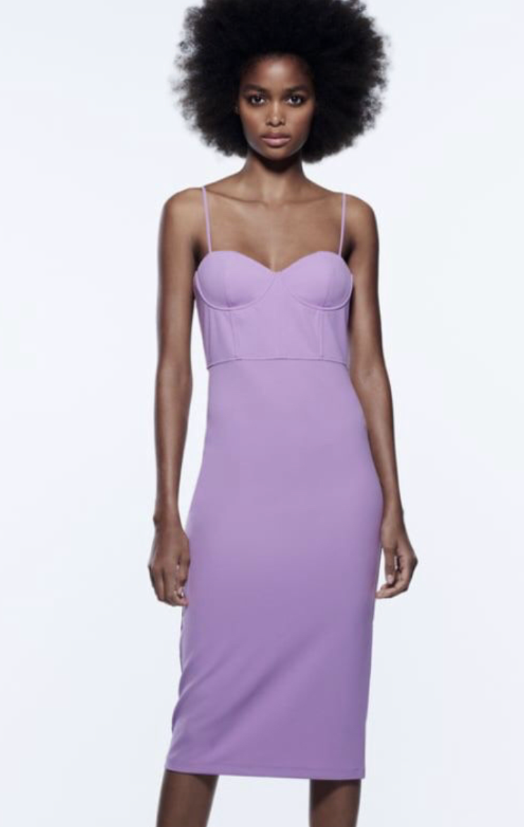 Woman wearing a lavender dress against a white background