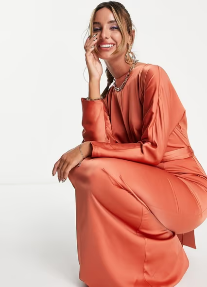 Woman wearing a coral-colored outfit on a white background