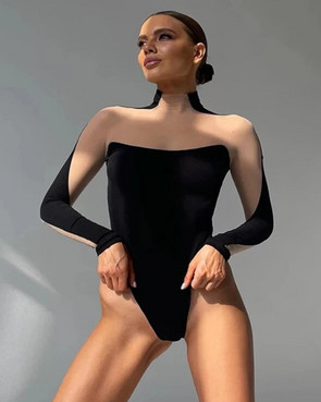 Woman wearing a black off-shoulder bodysuit against a gray background
