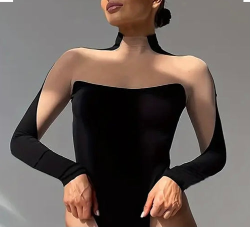 Woman wearing a black strapless dress with long sleeves on a gray background