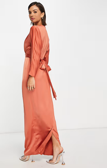 Woman wearing a rust-colored dress with a white background