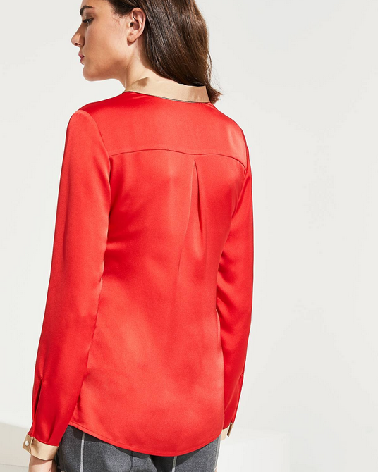 Woman wearing a red blouse with a plain background